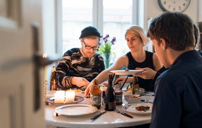 Måltidsmiljö med personer som äter mat och dricker öl.