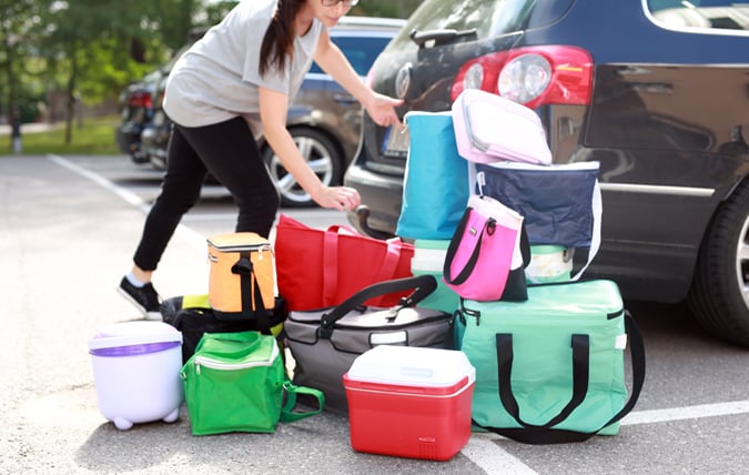 Kvinna packar in kylväskor i bilen